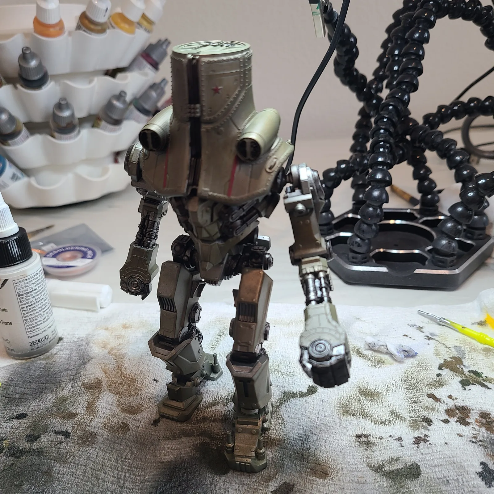 A robot miniature on a paint-covered workbench