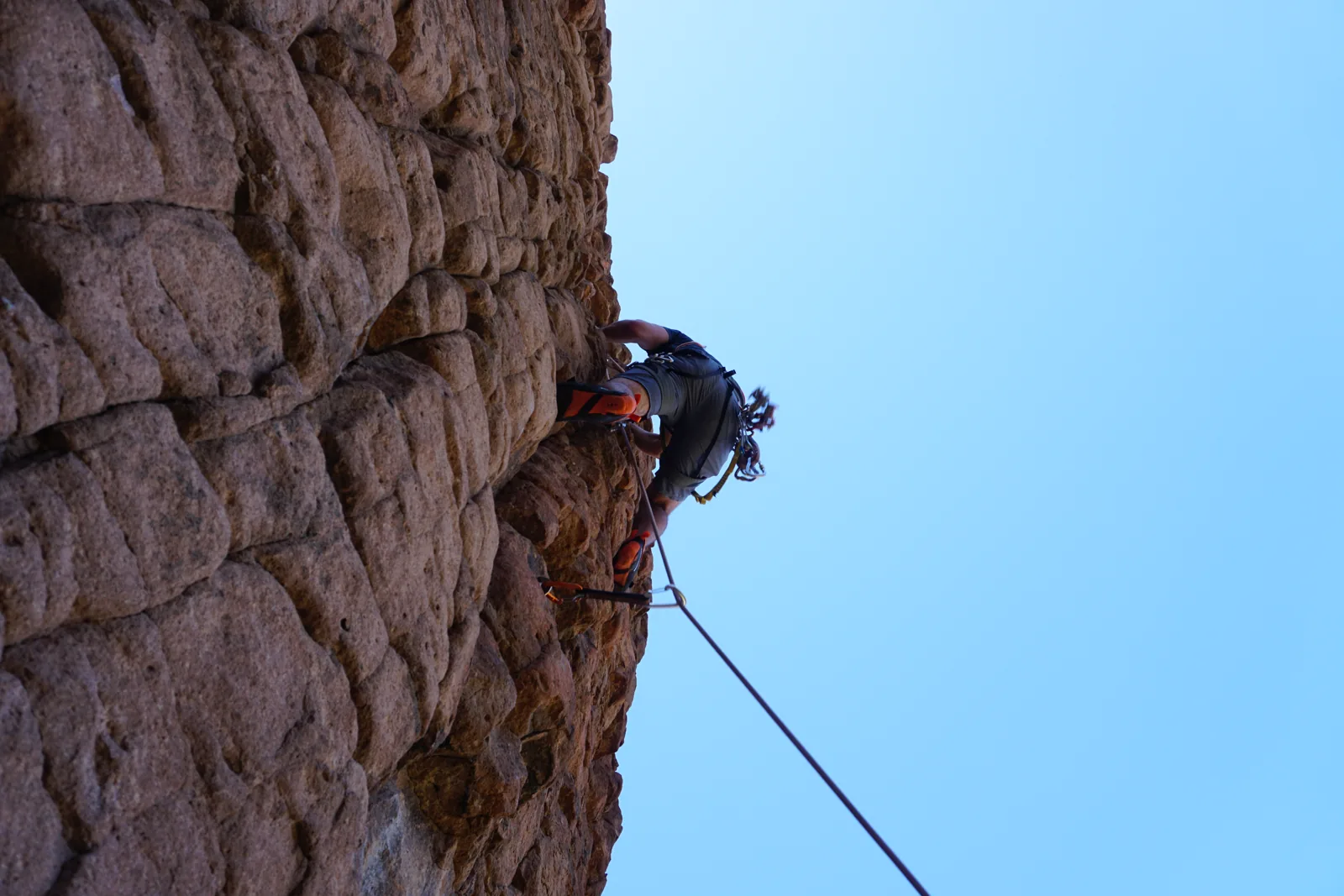 A climber ascending a steep rock face