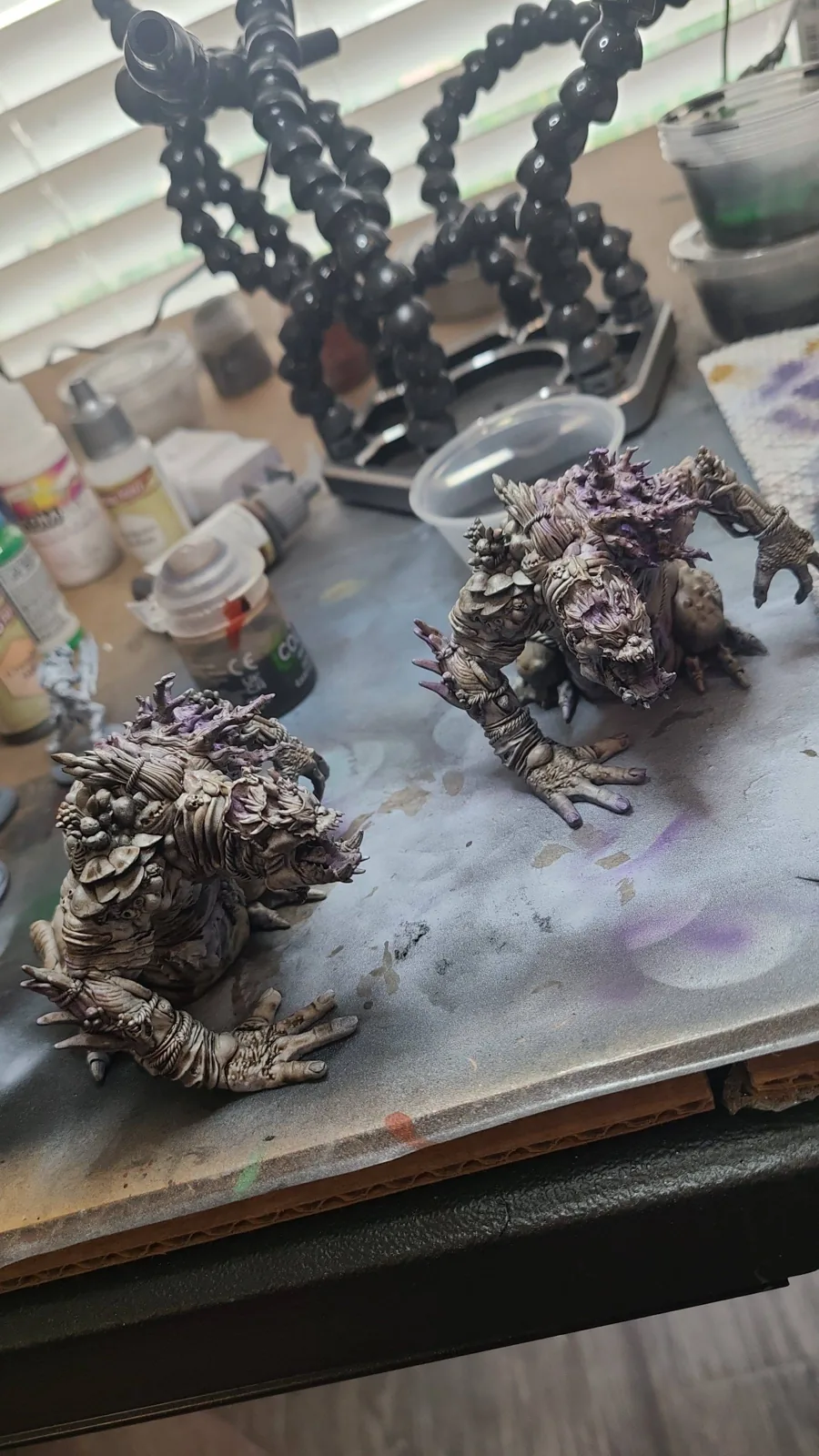 Several fantasy miniatures arranged on a painting workbench